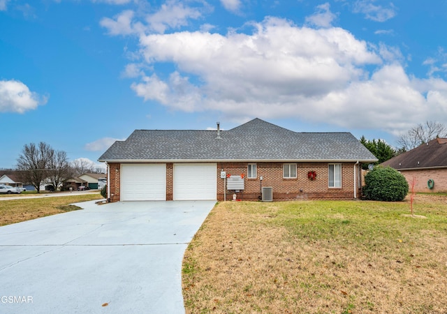 view of front of house with a front yard, central AC unit, and a garage