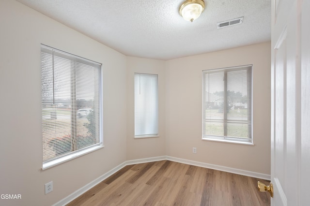 empty room featuring light hardwood / wood-style floors and a textured ceiling