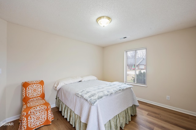 bedroom with hardwood / wood-style floors and a textured ceiling