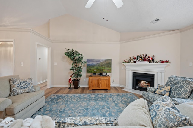 living room with ceiling fan, light hardwood / wood-style flooring, crown molding, and lofted ceiling