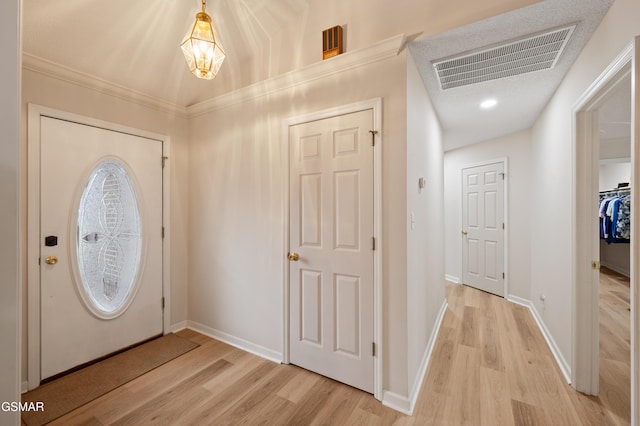 foyer entrance featuring light hardwood / wood-style floors and ornamental molding