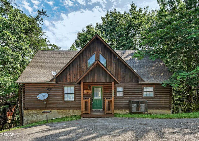 cabin with a shingled roof and log siding