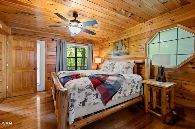 bedroom with light wood-type flooring, wooden ceiling, and wood walls