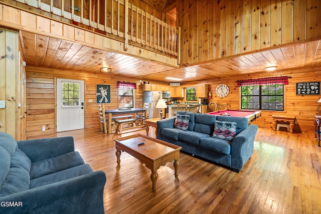 living room with wood walls, light wood finished floors, and wooden ceiling