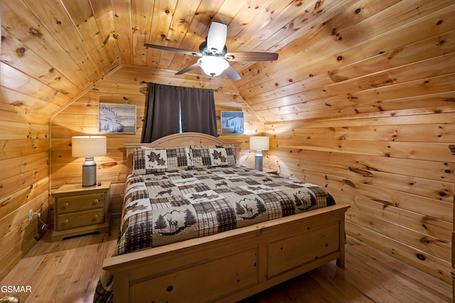 bedroom featuring vaulted ceiling, wood ceiling, wooden walls, light wood-style floors, and ceiling fan