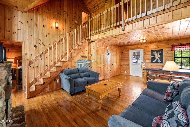 living area featuring wood walls, stairs, hardwood / wood-style floors, and wooden ceiling