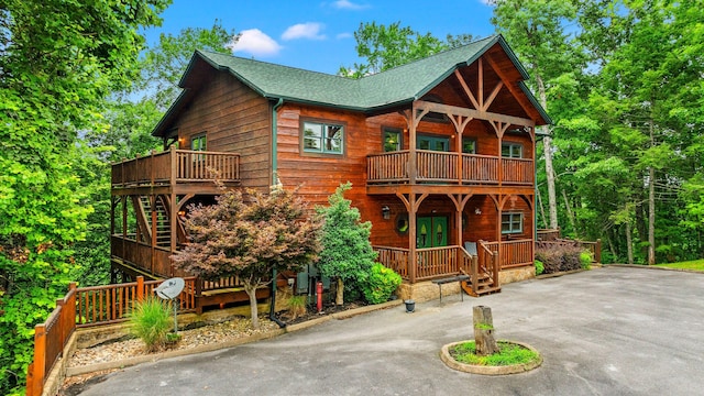 log-style house with a balcony and french doors