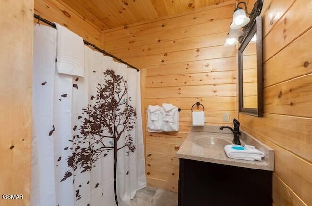 bathroom with wood walls, vanity, wood ceiling, and walk in shower