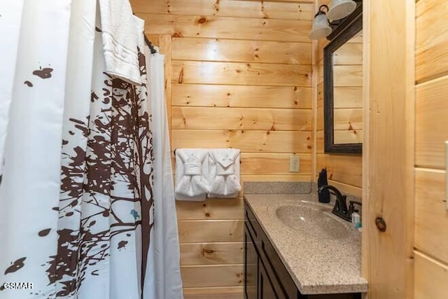 bathroom featuring vanity and wood walls