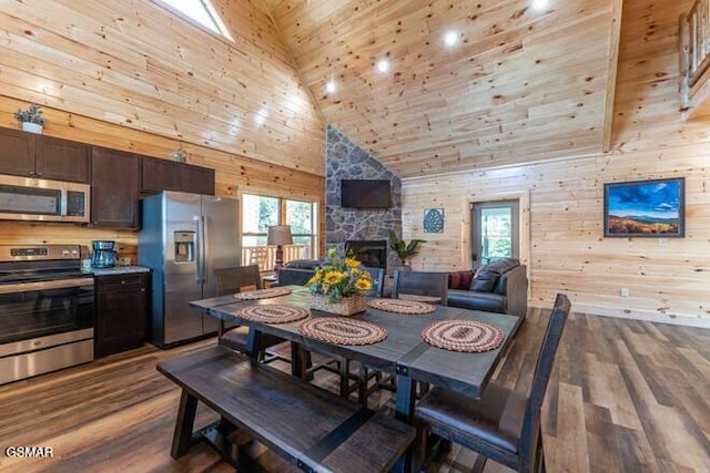 dining space featuring wooden walls, hardwood / wood-style floors, and high vaulted ceiling