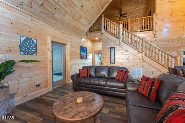 living room with dark wood-type flooring, ceiling fan, and wooden walls