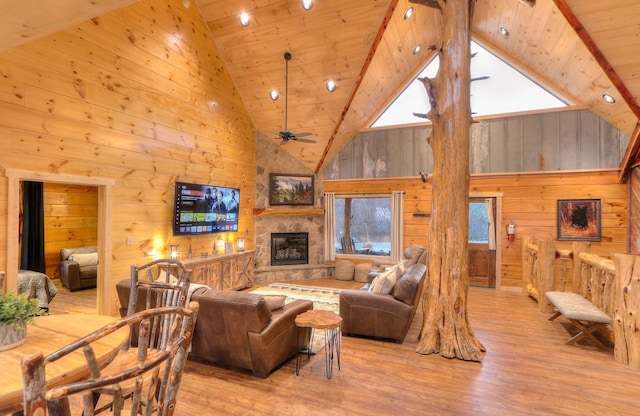 living room with ceiling fan, a fireplace, high vaulted ceiling, and wooden ceiling