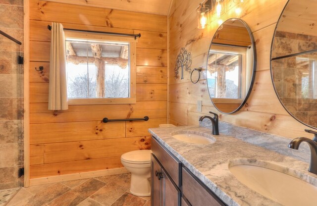 bathroom with vanity, toilet, and wood walls