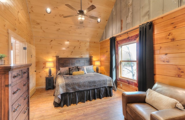 bedroom featuring wood walls, ceiling fan, light hardwood / wood-style floors, and wood ceiling