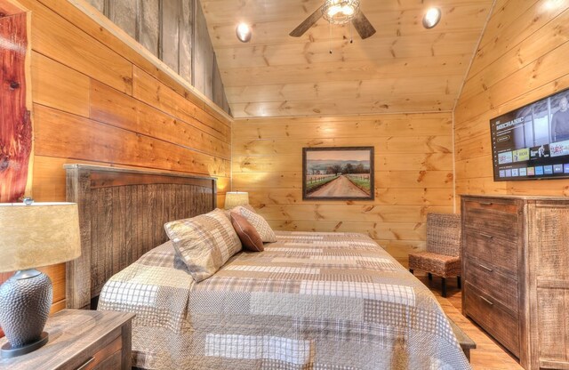 bedroom featuring ceiling fan, wood ceiling, and wooden walls