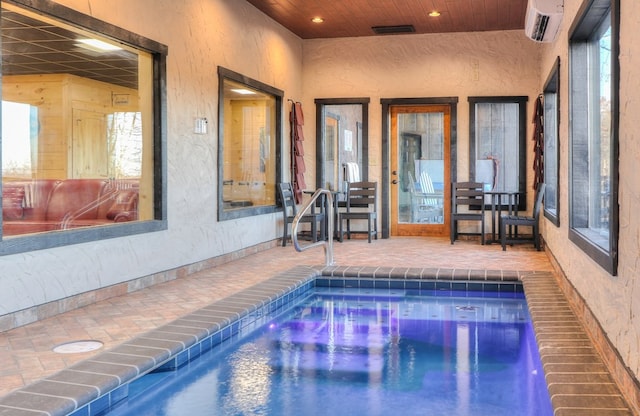 view of swimming pool with a patio area and a wall unit AC