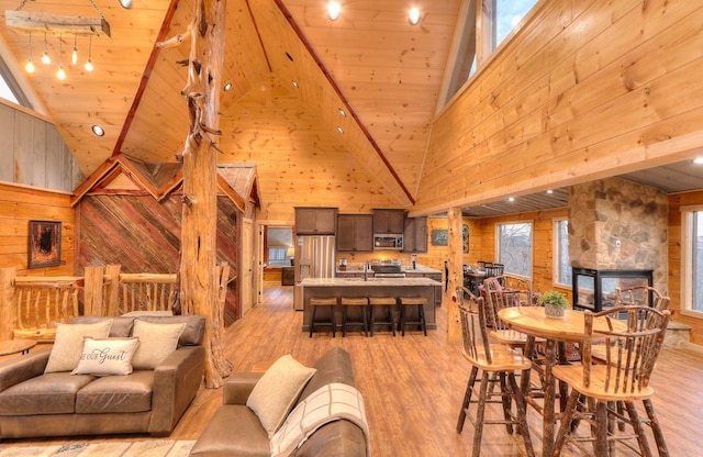 interior space with wood walls, high vaulted ceiling, and wooden ceiling