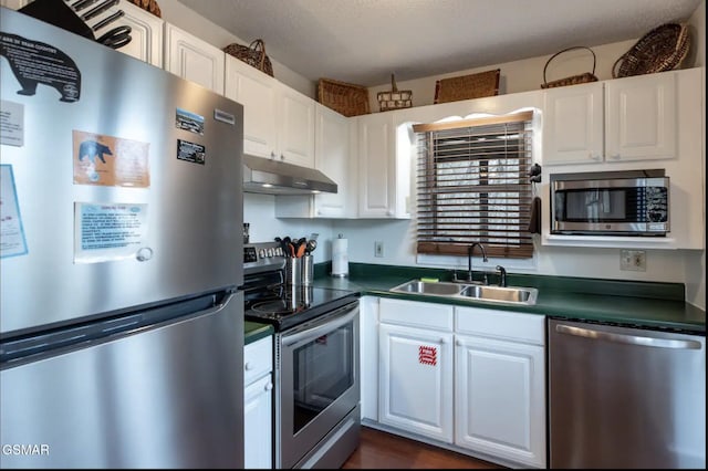 kitchen with a textured ceiling, stainless steel appliances, white cabinetry, and sink