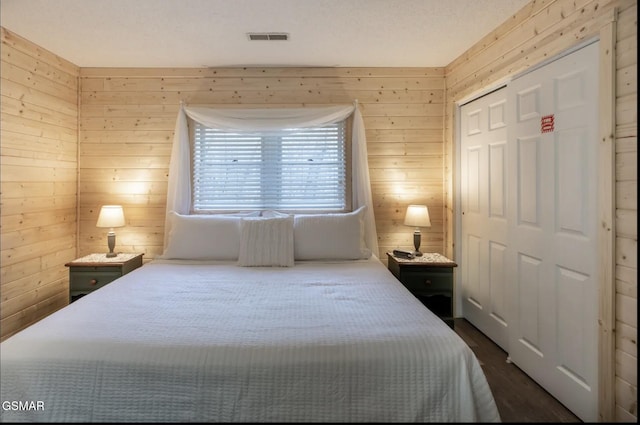 bedroom featuring wood walls and a closet