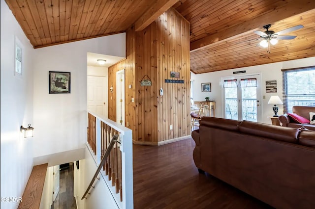 living room with wooden walls, vaulted ceiling with beams, ceiling fan, dark hardwood / wood-style flooring, and wood ceiling