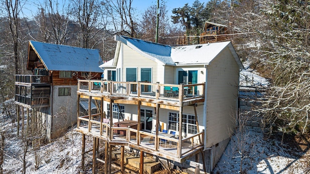 snow covered property with a balcony