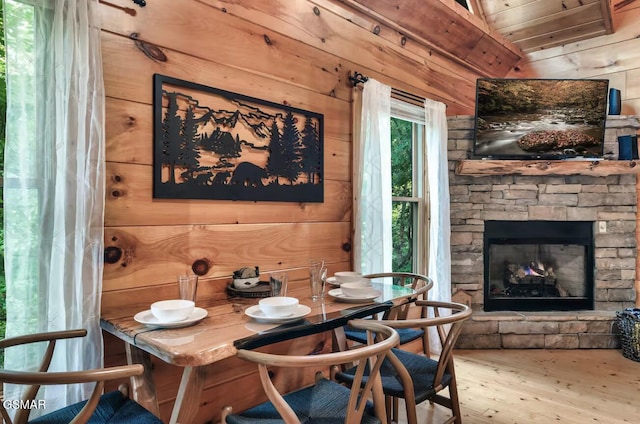 1502 Sky View Dr, Sevierville, TN 37876 - dining room featuring wood finished floors, wood walls, lofted ceiling, and a fireplace