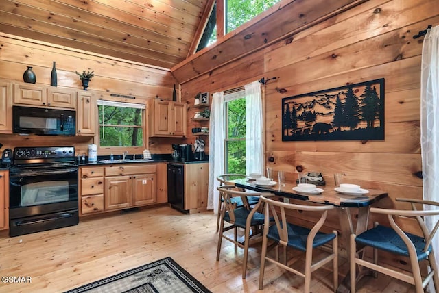 1502 Sky View Dr, Sevierville, TN 37876 - kitchen with black appliances, vaulted ceiling, light wood-type flooring, dark countertops, and wooden walls