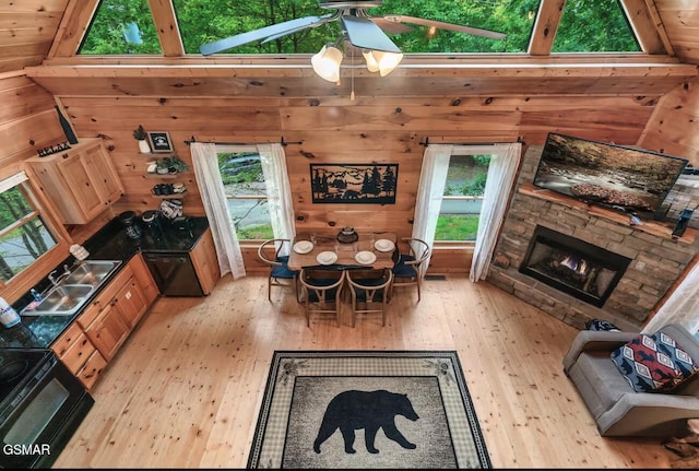 1502 Sky View Dr, Sevierville, TN 37876 - dining room featuring light wood-type flooring, healthy amount of natural light, wooden walls, a stone fireplace, and ceiling fan