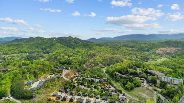 drone / aerial view featuring a mountain view and a wooded view