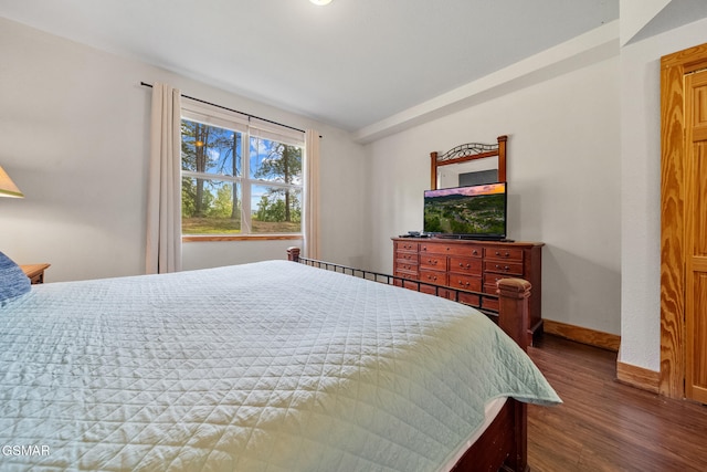 bedroom featuring baseboards, vaulted ceiling, and wood finished floors