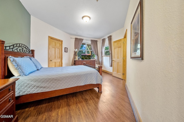 bedroom featuring baseboards and wood finished floors