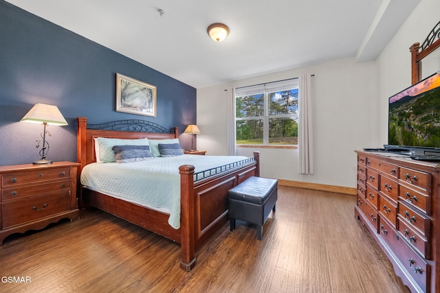 bedroom featuring baseboards and wood finished floors