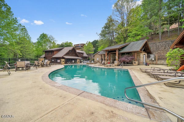 community pool featuring fence and a patio area