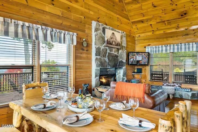 3933 Glenview Way, Sevierville, TN 37862 - dining space featuring wood walls, a stone fireplace, high vaulted ceiling, and wood finished floors