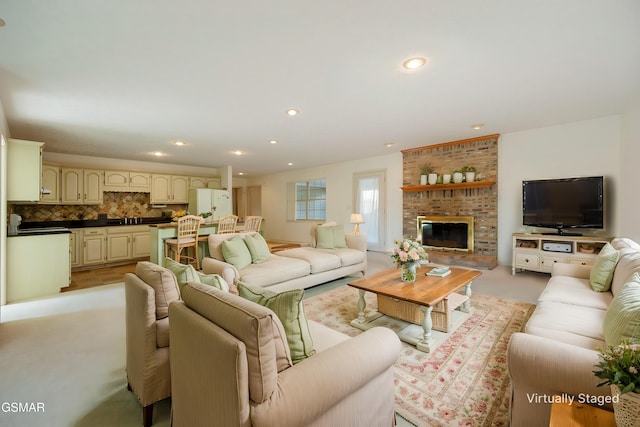 living area featuring recessed lighting, a fireplace, and light colored carpet