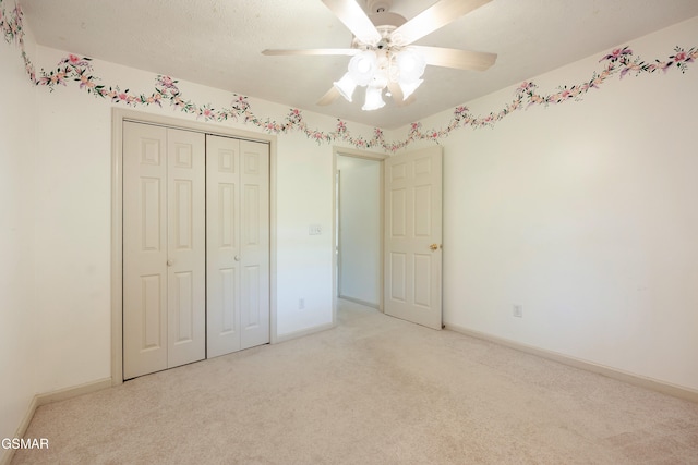 unfurnished bedroom featuring light carpet, a closet, baseboards, and a ceiling fan