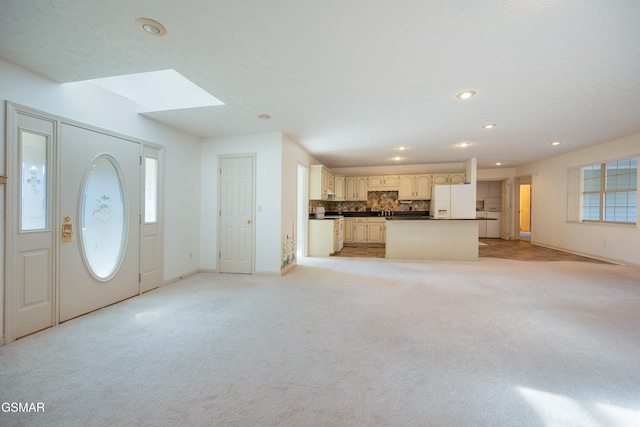 interior space featuring recessed lighting, baseboards, light carpet, and a skylight