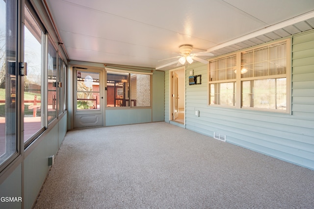 unfurnished sunroom featuring visible vents and ceiling fan