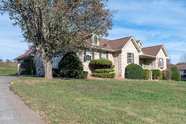 view of front facade featuring brick siding, aphalt driveway, a front lawn, and roof with shingles