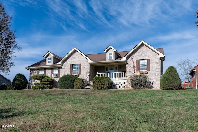 view of front facade featuring cooling unit, brick siding, covered porch, and a front yard