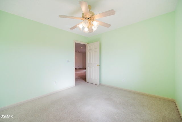 unfurnished room featuring light carpet, a ceiling fan, and baseboards