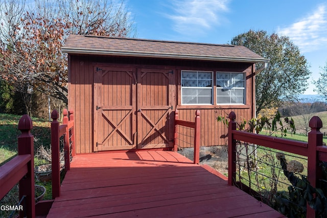 wooden deck with an outdoor structure and a shed