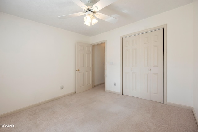 unfurnished bedroom with a ceiling fan, light colored carpet, a closet, and baseboards