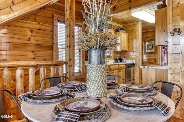 dining space with rustic walls and wood walls