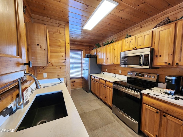 kitchen with stainless steel appliances, sink, wooden ceiling, and wood walls