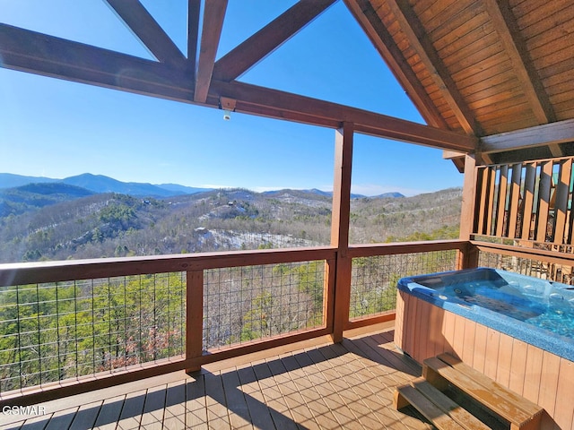 wooden deck featuring a hot tub and a mountain view