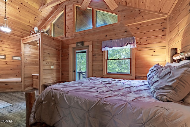 bedroom featuring vaulted ceiling with beams, access to outside, wood finished floors, and wooden walls