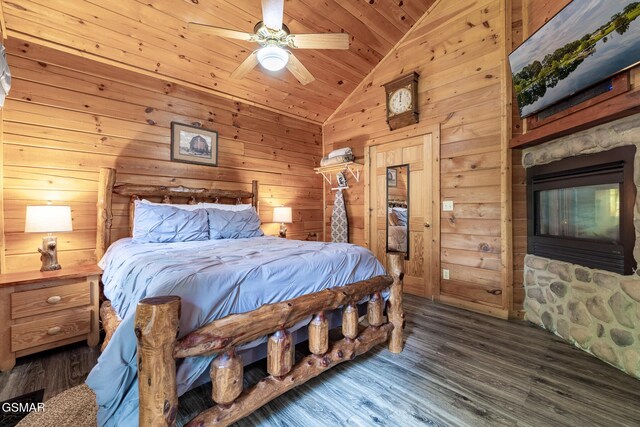 bedroom featuring ceiling fan, wood finished floors, wooden ceiling, lofted ceiling, and wooden walls