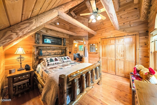bedroom with wooden ceiling, light wood finished floors, and wood walls