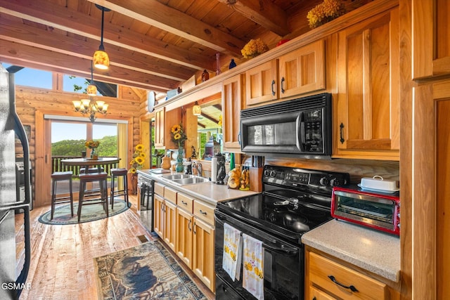 kitchen featuring black appliances, wood ceiling, a chandelier, light countertops, and a sink